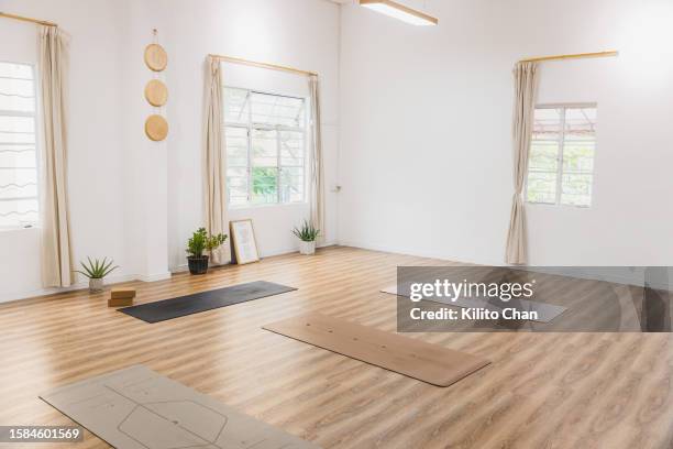 empty bright yoga studio with yoga mat on the floor - exercise room stock pictures, royalty-free photos & images