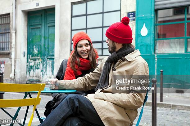 young couple sitting outside a restaurant - red scarf stock-fotos und bilder