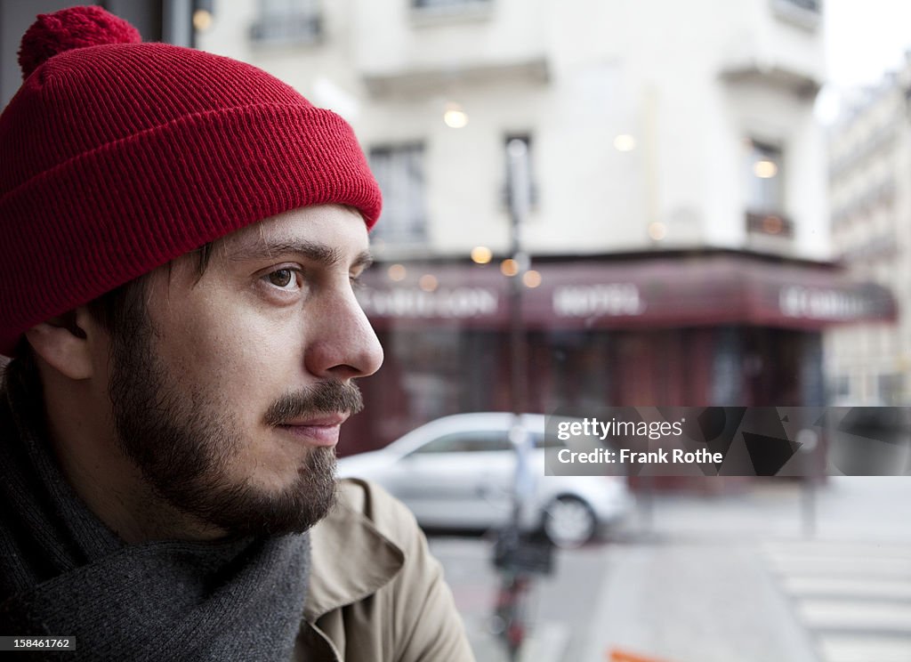 Portrait of young man near a window to the street