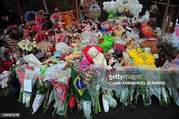 Offerings stand at a makeshift shrine to the victims of an elementary school shooting in Newtown, Connecticut, December 17, 2012. Funerals began...