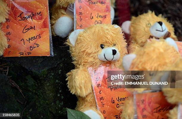 Teddy bears show the names of some of the victims of an elementary school shooting, including Jack Pinto, at a makeshift shrine to the victims of an...