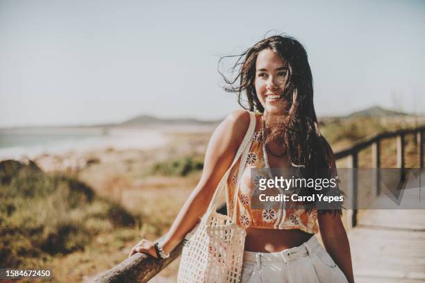 young woman with  long, thick, wavy hair,  walking to the beach - thick girls stockfoto's en -beelden