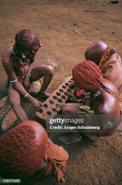 Masai tribespeople in Kenya playing a Mancala board game, 1973.