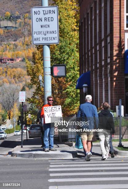 Man standing at a street corner in Aspen, Colorado, urges pedestrians ito register to vote for the 2012 presidential election....