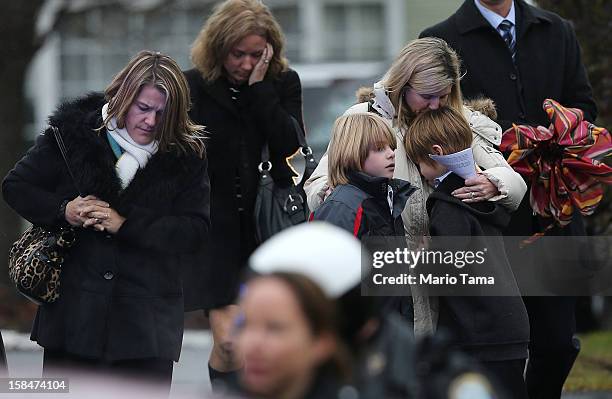 Woman comforts a boy as mourners depart Honan Funeral Home after the funeral for 6-year-old Jack Pinto on December 17, 2012 in Newtown Connecticut....