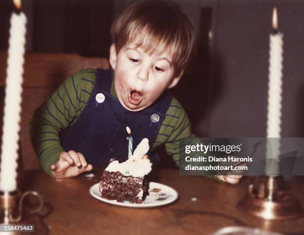 little boy blowing out his first birthday candle - vintage birthday imagens e fotografias de stock