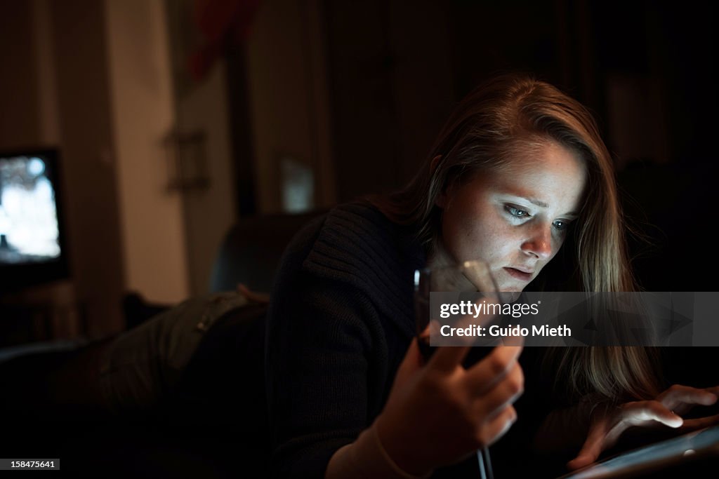 Woman using tablet on couch.