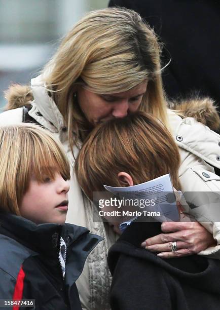 Woman comforts a boy as mourners depart Honan Funeral Home after the funeral for six-year-old Jack Pinto on December 17, 2012 in Newtown Connecticut....
