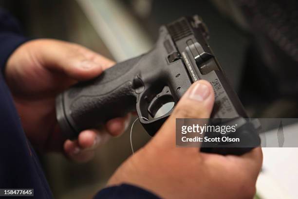 Customer shops for a pistol at Freddie Bear Sports sporting goods store on December 17, 2012 in Tinley Park, Illinois. Americans purchased a record...