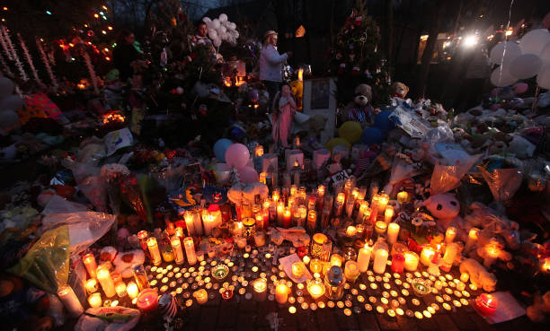 Candles are lit among mementos at a memorial for victims of the mass shooting at Sandy Hook Elementary School, on December 17, 2012 in Newtown,...