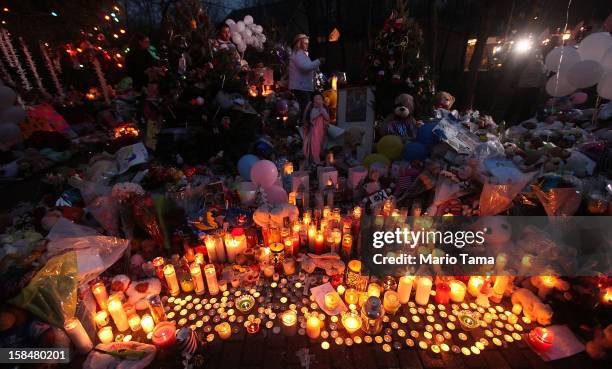 Candles are lit among mementos at a memorial for victims of the mass shooting at Sandy Hook Elementary School, on December 17, 2012 in Newtown,...