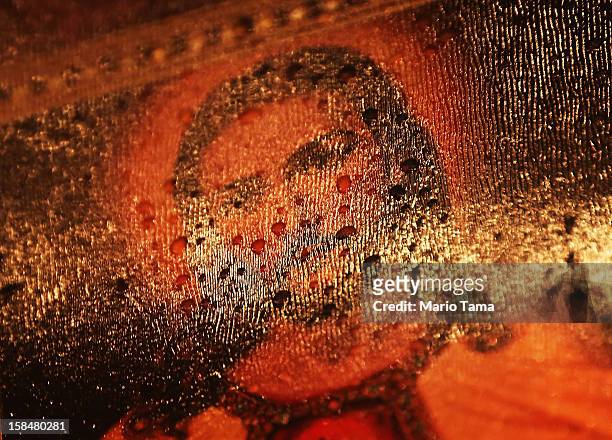 Raindrops rest on a Jesus painting at a memorial for victims of the mass shooting at Sandy Hook Elementary School, on December 17, 2012 in Newtown,...