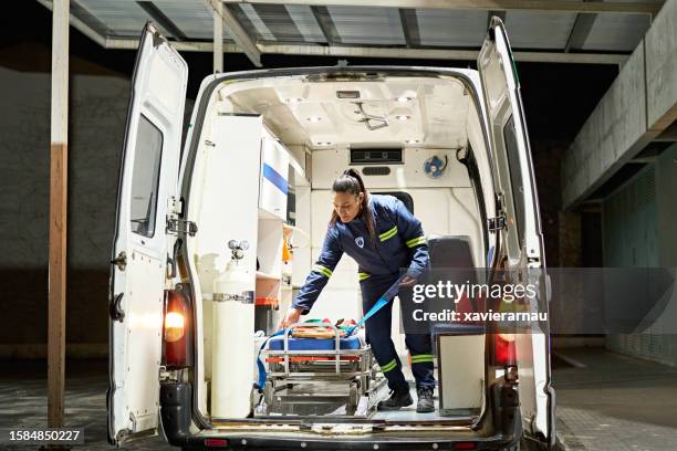 young female paramedic organizing ambulance interior - ambulance stockfoto's en -beelden