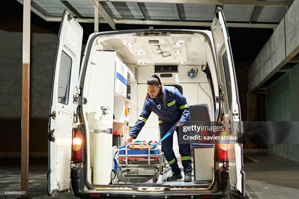 Young female paramedic organizing ambulance interior
