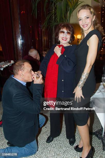 Helene de Fougerolles, Judith Magre and Pierre Laville pose at restaurant Le Grand Colbert on December 17, 2012 in Paris, France.