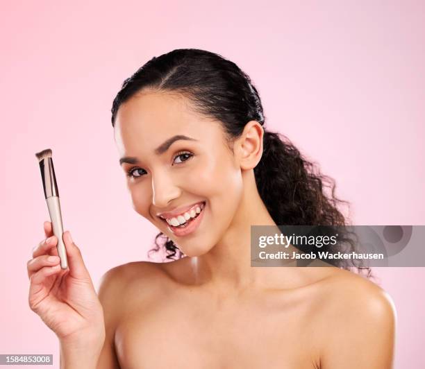 Beauty, makeup and brush with portrait of woman in studio for foundation, cosmetics and facial. Skincare, health and self care with face of model on pink background for dermatology, glow and product