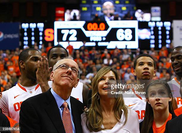 Head coach Jim Boeheim of the Syracuse Orange looks on to the video screens as he stands next to wife, Juli Boeheim and daughter Jamie Boeheim to...