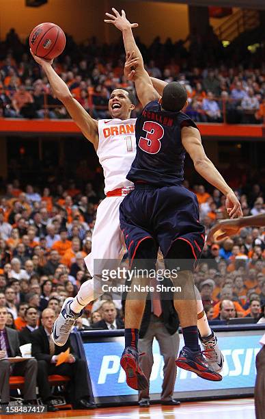 Michael Carter-Williams of the Syracuse Orange puts the ball up to the basket against Ray McCallum of the Detroit Titans during the game at the...