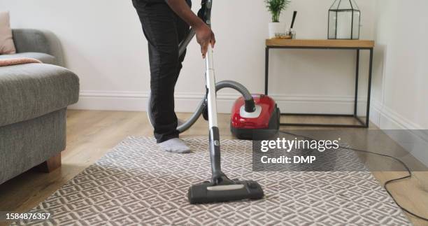 carpet, person and cleaning with a vacuum cleaner in a home lounge for dust, dirt and maintenance. legs closeup of an adult with an electric appliance for vacuuming living room floor in a clean house - maid hoovering stock pictures, royalty-free photos & images