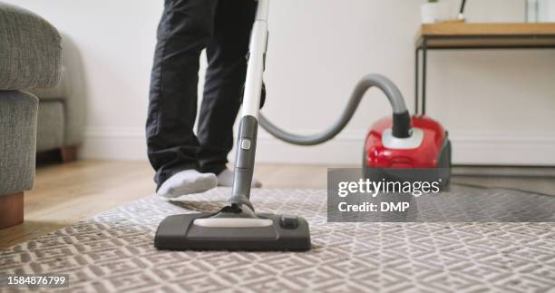 carpet, vacuum cleaner and a person cleaning in a home lounge for dust, dirt and maintenance. legs closeup of an adult with an electric appliance for vacuuming the living room floor in a clean house - maid hoovering stock pictures, royalty-free photos & images