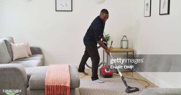 carpet, vacuum cleaner and a man cleaning in a home lounge for dust, dirt and maintenance. happy black male person with an electric appliance for vacuuming living room floor for a clean house - maid hoovering stock pictures, royalty-free photos & images