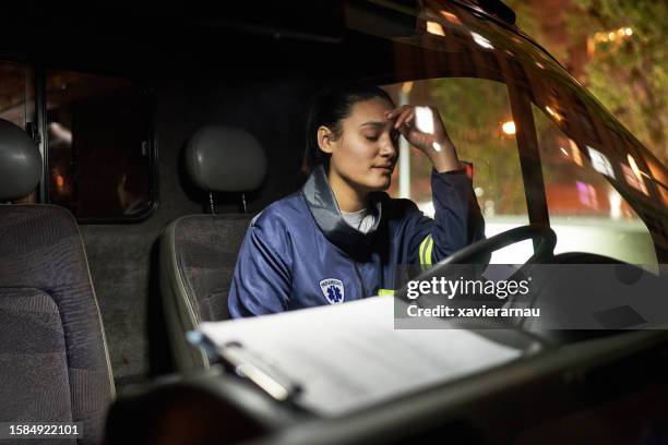 exhausted paramedic sitting in driver’s seat - pessoal de ambulância imagens e fotografias de stock