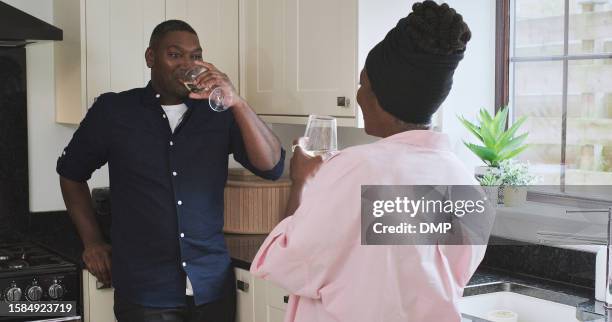 afternoon, wine and a black couple in the kitchen of their home together for conversation or bonding. love, smile or happy with a man and woman drinking alcohol to relax while talking in the house - day anniversary stock pictures, royalty-free photos & images