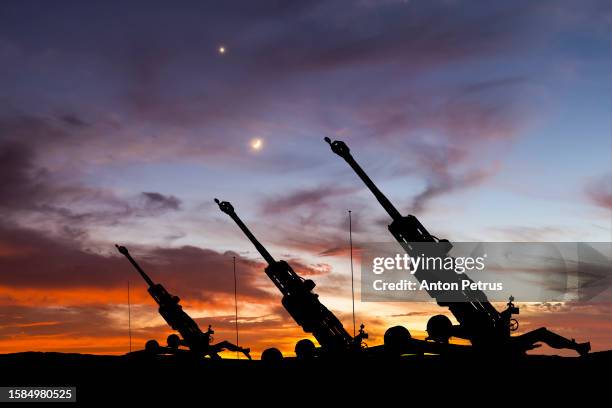 howitzer on the background of the sunset sky - haubitze stock-fotos und bilder