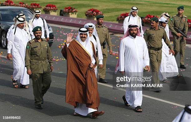 Surrounded by security, Qatari Emir Sheikh Hamad bin Khalifa al-Thani arrives to attend the Gulf emirate's National Day celebrations in Doha on...