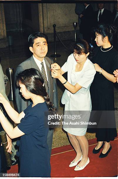 Newly elected lower house lawmaker Shinzo Abe is attached the diet member's pin by a diet staff as he first ever attend the diet session on August 5,...