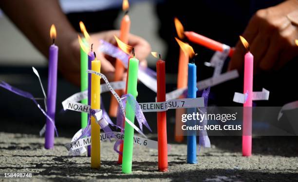 Members of human rights group, Volunteers Against Crime and Corruption , light candles with names of those killed during the shooting at Sandy Hook...