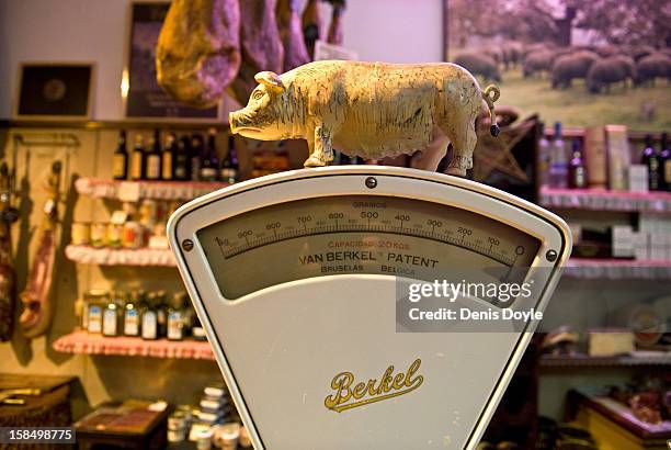 Small figurine of an Iberian Pig sits on an old weighing scales at the Alberto Lopez Araque jamon Iberico shop on December 14, 2012 in Madrid, Spain....