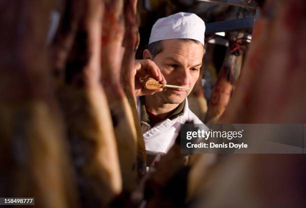 An emproyee of the company Fermin Jamones smells a sample from a leg of dry-cured Jamon Iberico de bellota in the village of La Alberca on December...