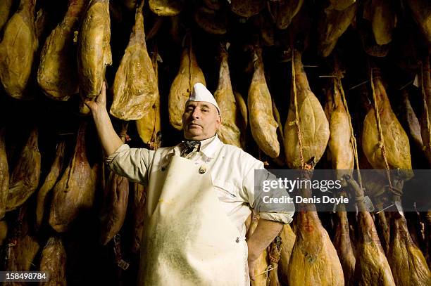 Basilio Hoyos, manager of the Sociedad Chacinera Albercana Cooperative is photographed beside leg of dry-cured Jamon Iberico de bellota in the...