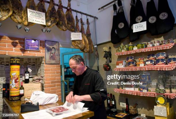 An employee of the Alberto Lopez Araque jamon shop in Madrid wraps a selection of dry-cured Jamon Iberico de bellota on December 14, 2012 in Madrid,...