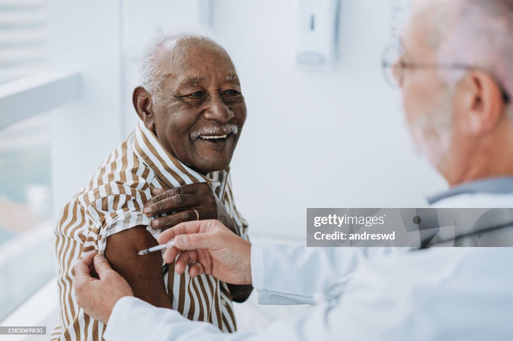 Doctor giving vaccine to patient