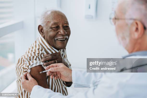 doctor giving vaccine to patient - old guy stock pictures, royalty-free photos & images