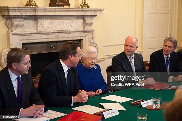 Queen Elizabeth II sits next to British Prime Minister David Cameron and Foreign Secretary William Hague at Number 10 Downing Street as she attends...