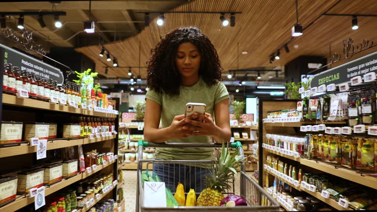 https://media.gettyimages.com/id/1585140899/video/black-young-woman-leaning-on-the-shopping-cart-while-walking-through-the-supermarket-and.jpg?b=1&s=640x640&k=20&c=87OnXbilHlTlZ5dRp0fY3HZR3omR8stKmj1vQ0loWJw=