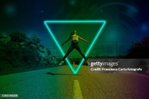 young woman jumping inside neon metaverse portal - triangle shape stock pictures, royalty-free photos & images