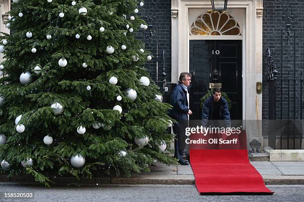 Downing Street staff lay a red carpet outside Number 10 in advance of the arrival of Her Majesty Queen Elizabeth II to attend the Government's weekly...