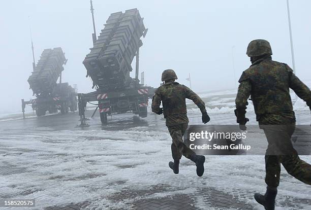 Members of the German Bundeswehr rush toward two Patriot missile launching systems during a press day presentation at the Luftwaffe Warbelow training...