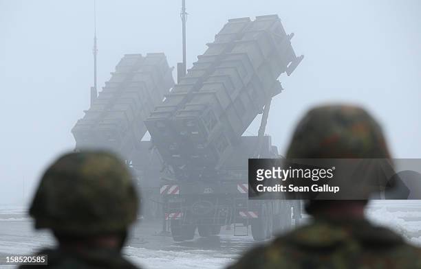 Members of the German Bundeswehr look on as two Patriot missile launching systems stand ready during a press day presentation at the Luftwaffe...