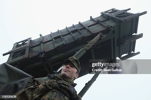 Member of the German Bundeswehr who will be sent to Turkey stands next to a Patriot missile launching system during a press day presentation at the...