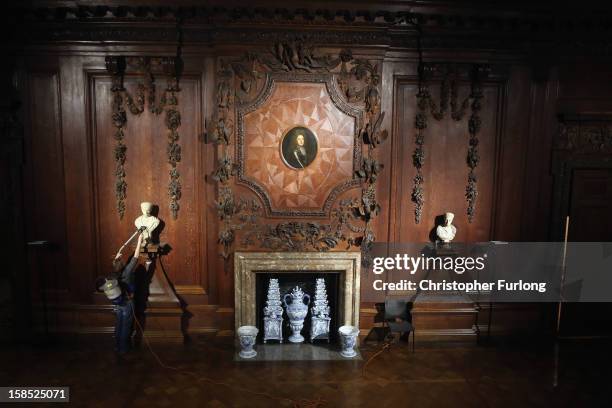 Chatsworth House house cleaning assistant Louise Randall uses a back pack vacuum cleaner to clean a fireplace during the process of deep cleaning at...