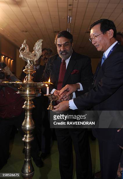 Cambodian Senior Minister and Minister of Commerce Cham Prasidh and Indian Minister for Commerce and Industry Anand Sharma light a oil lamp during...