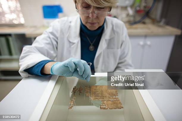 Conservation analyst from the Israeli Antiquities department prepares fragments of the 2000-year-old Dead Sea scrolls at a laboratory before...