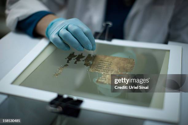 Conservation analyst from the Israeli Antiquities department prepares fragments of the 2000-year-old Dead Sea scrolls at a laboratory before...