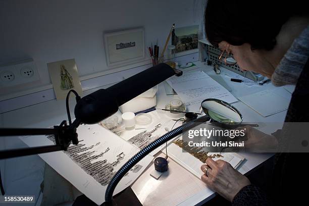 Conservation analyst from the Israeli Antiquities department examines fragments of the 2000-year-old Dead Sea scrolls at a laboratory before...