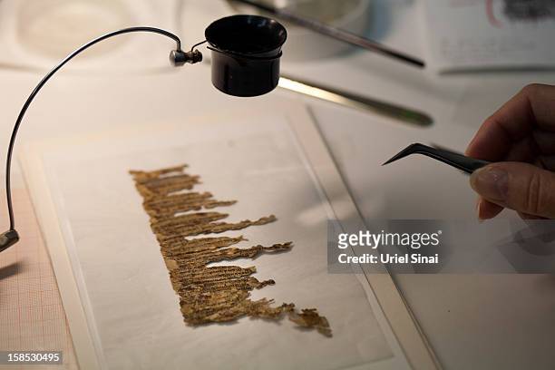 Conservation analyst from the Israeli Antiquities department examines fragments of the 2000-year-old Dead Sea scrolls at a laboratory before...